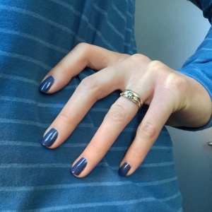 Blue-painted fingernails against a blue striped shirt